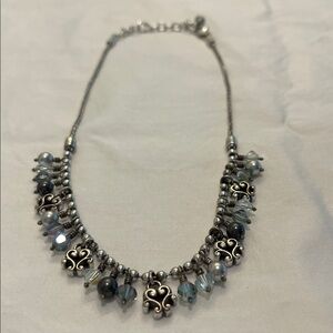 Brighton necklace with silver chain and blue stones , one extra stone at top.